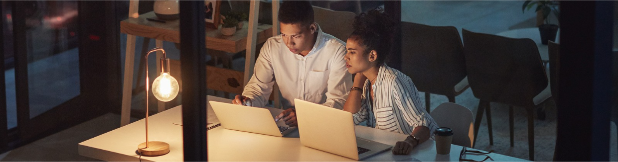 Man and woman sitting and looking at a laptop