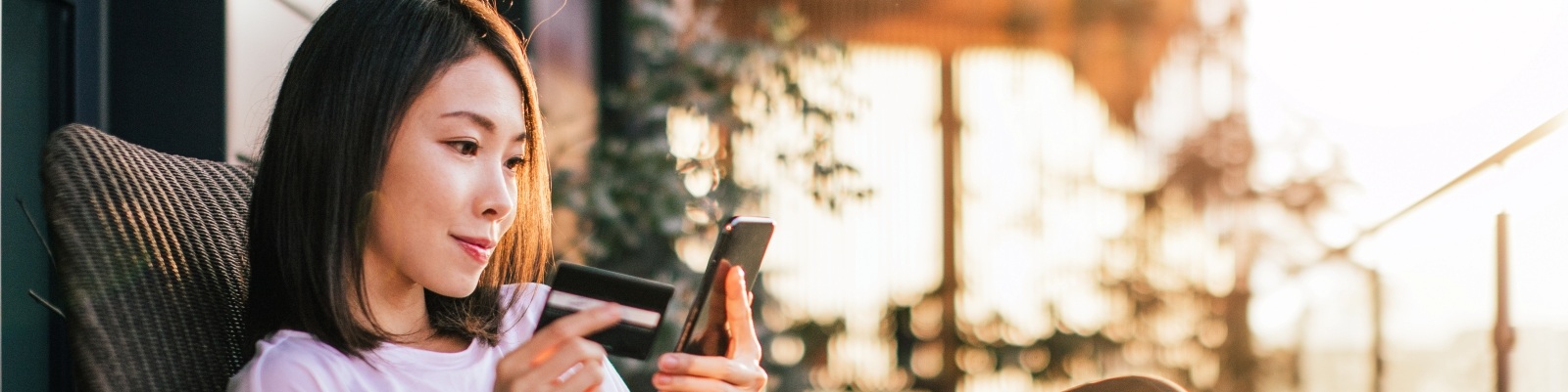Woman sitting looking at her phone smiling